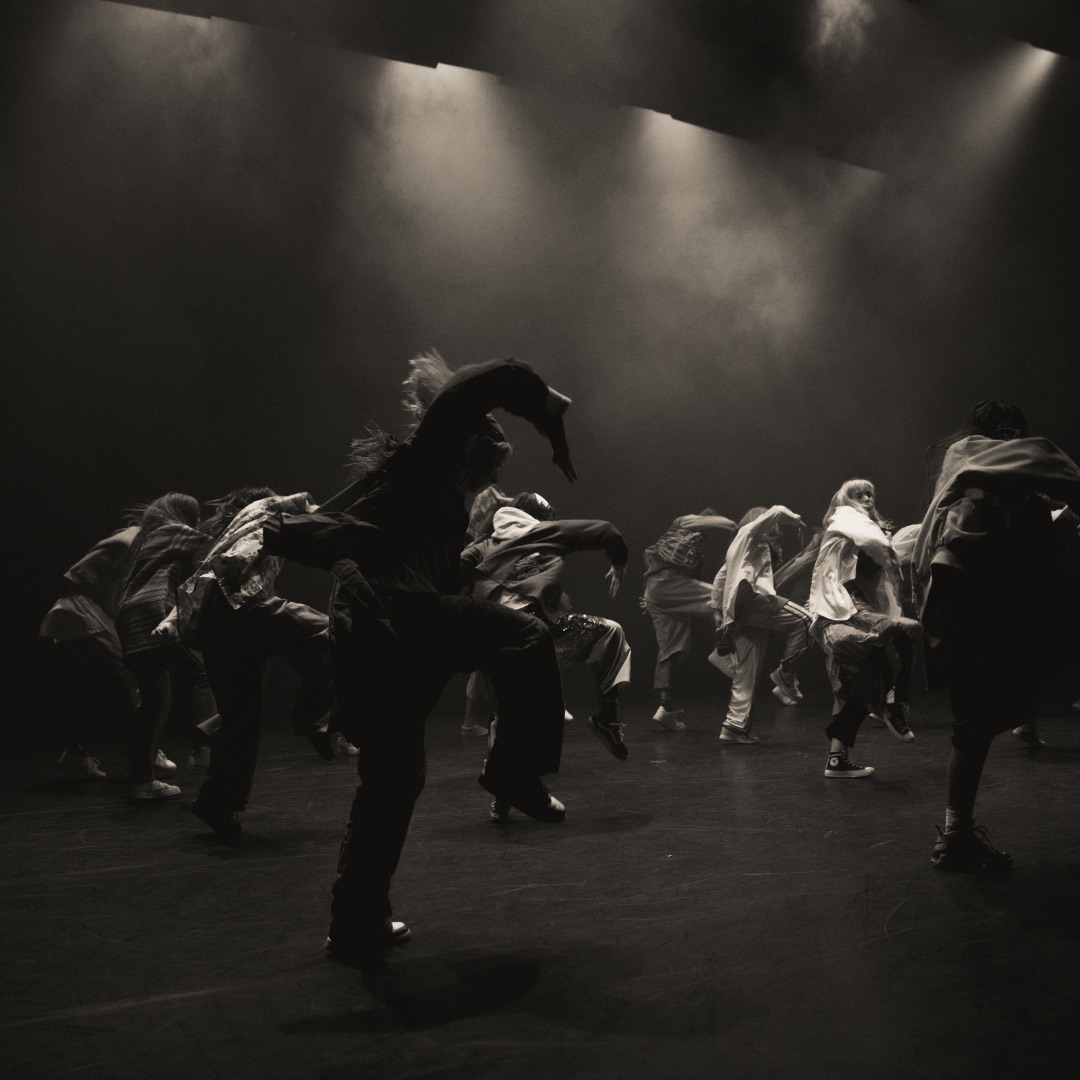 black and white photo of a group of dancers jumping in sequence