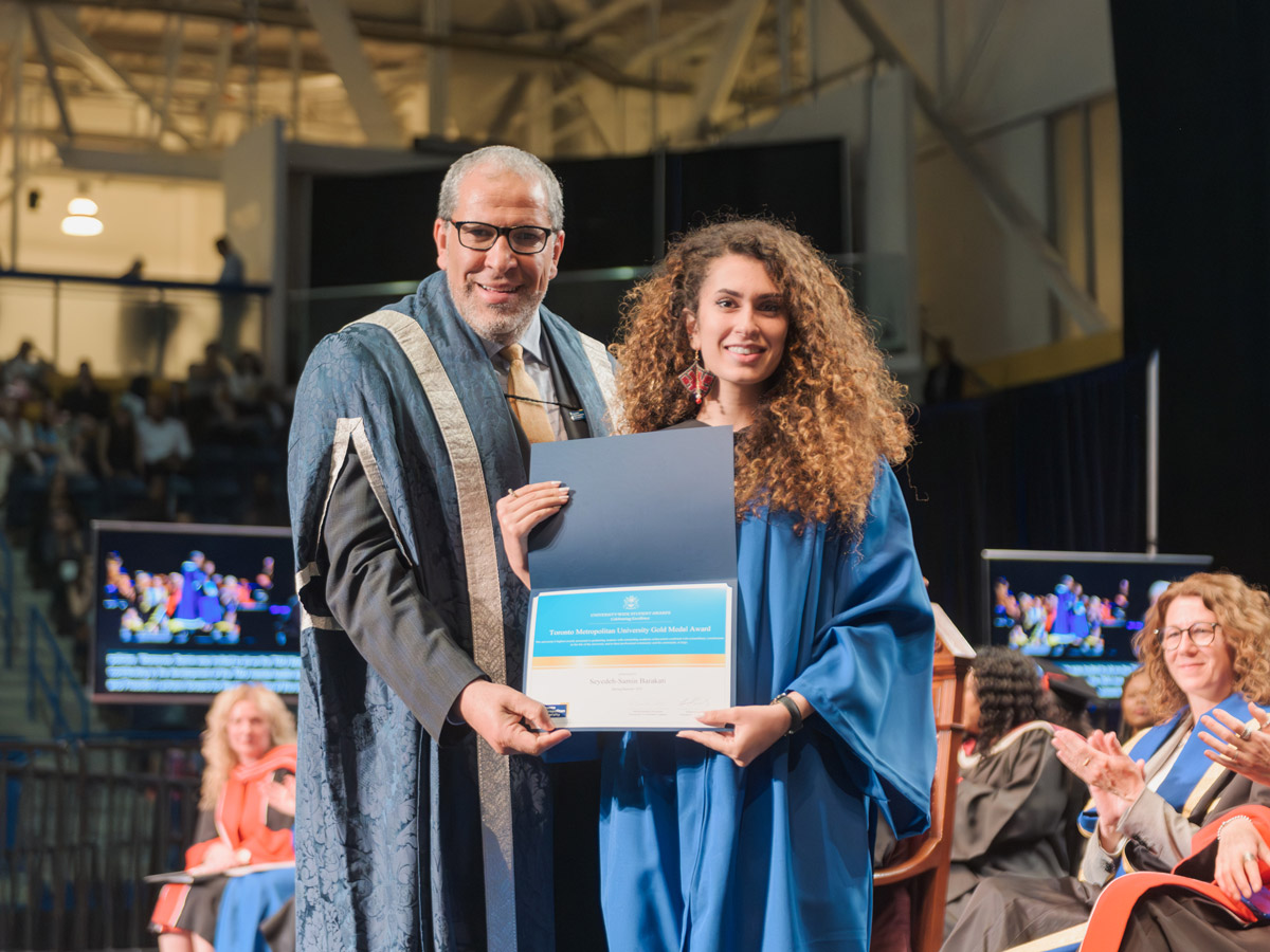 Samin Barakati, in her blue graduation robe, is presented with the TMU Gold Medal Award by TMU president, Dr. Mohamed Lachemi.