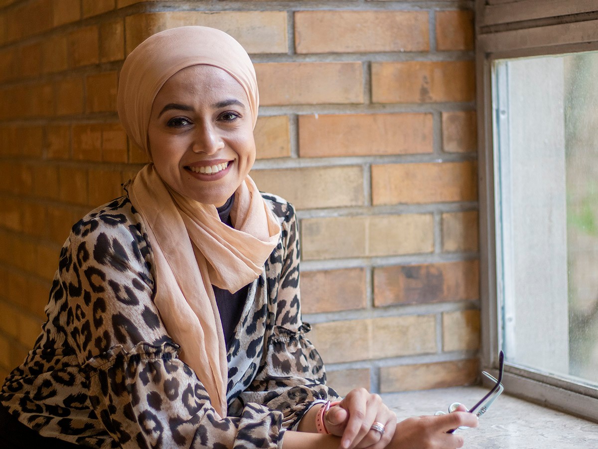 Professor Rania Hamza by a window smiling.