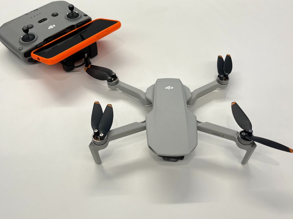 A quadcopter with a remote controller sitting on a table.