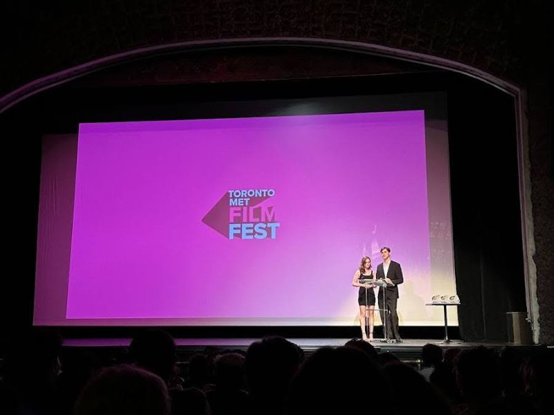 Two people speaking on stage at the Toronto Met Film Fest.