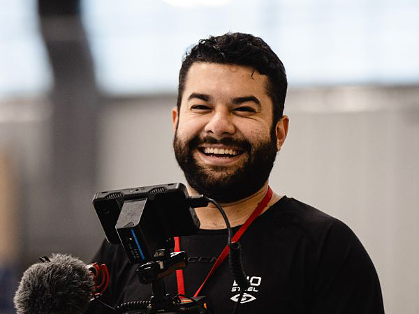 Portrait of Juan Morales holding camera equipment.