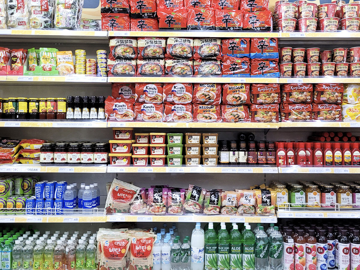 A grocery aisle shows a variety of international goods. 