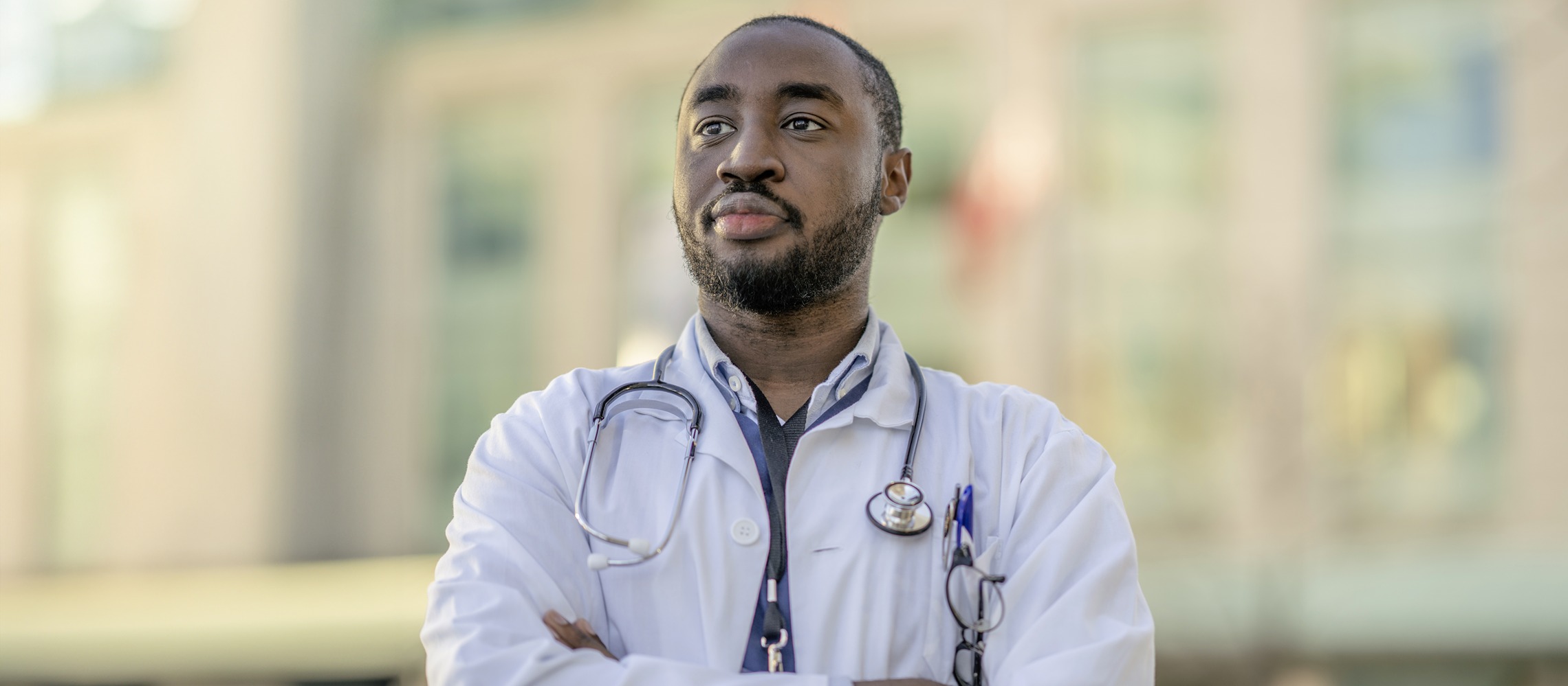 A Black male medical student gazes into the distance