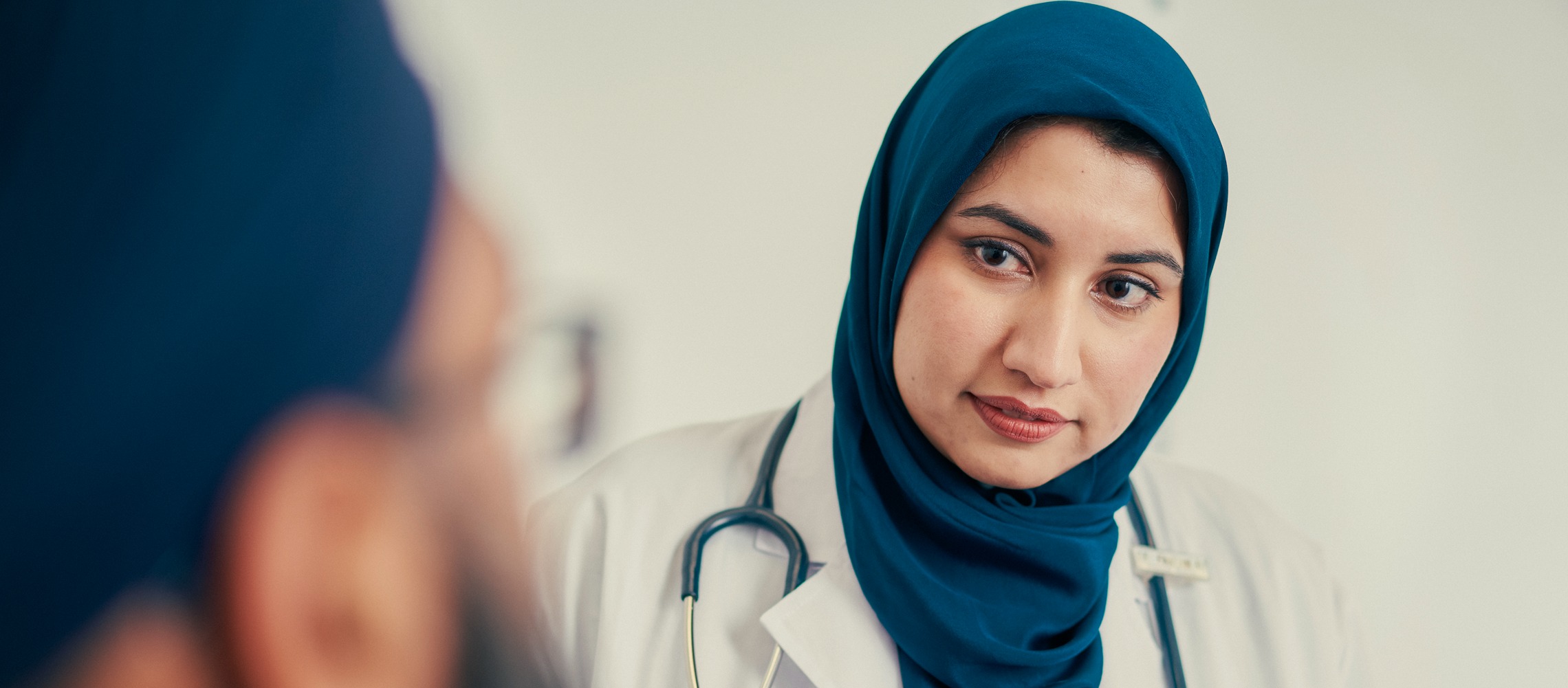 A Muslim female doctor consults with a patient