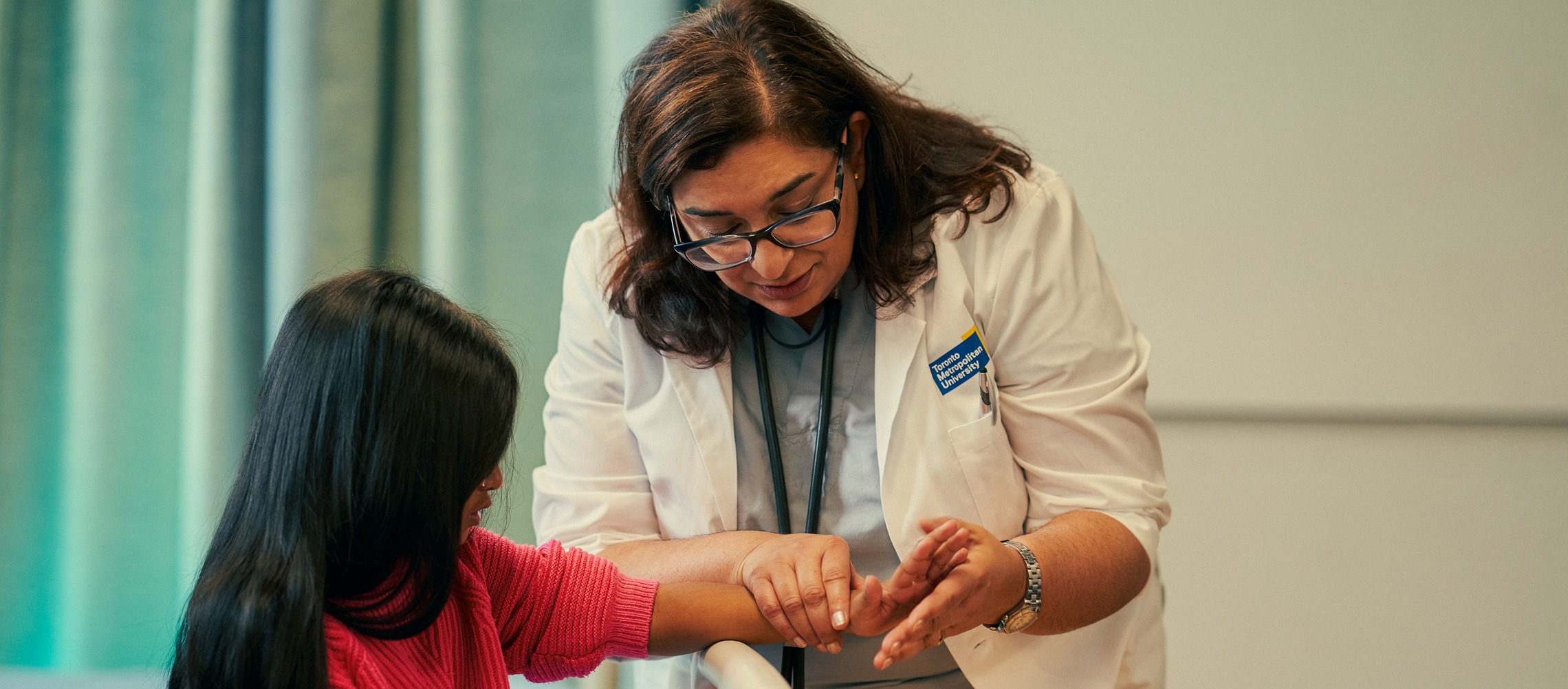 A female doctor examines a child's wrist