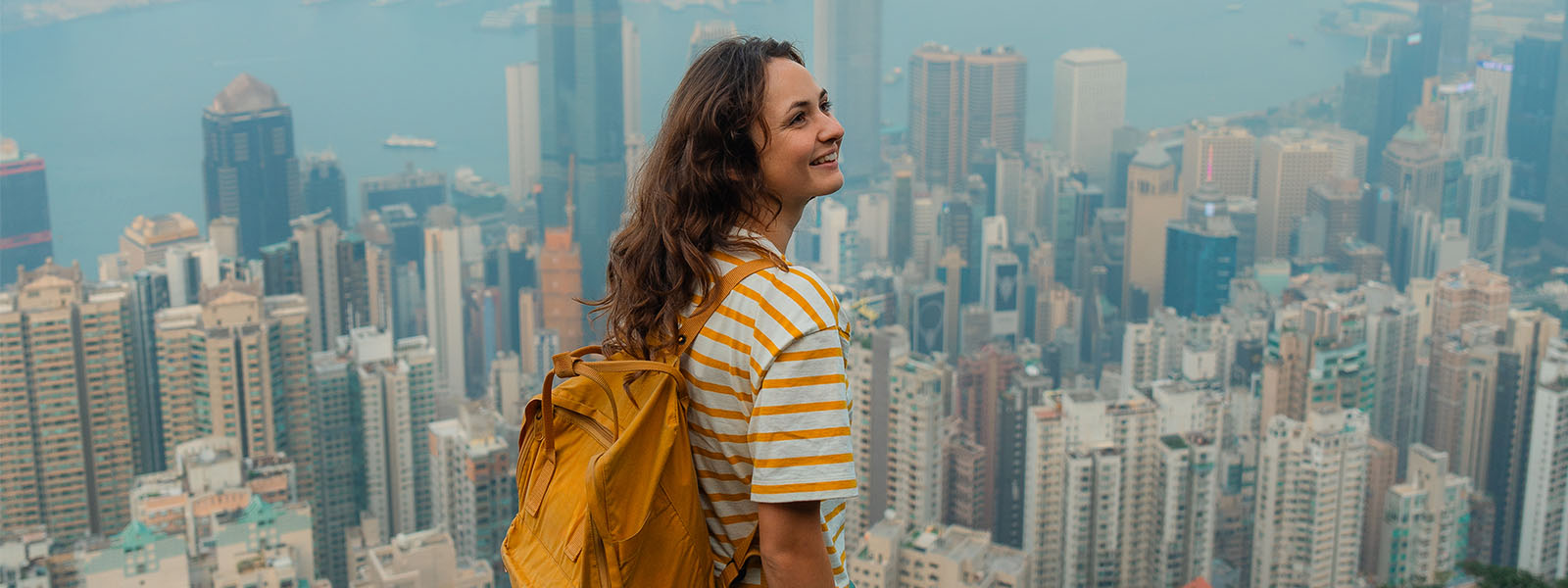 Smiling student with cityscape in background.