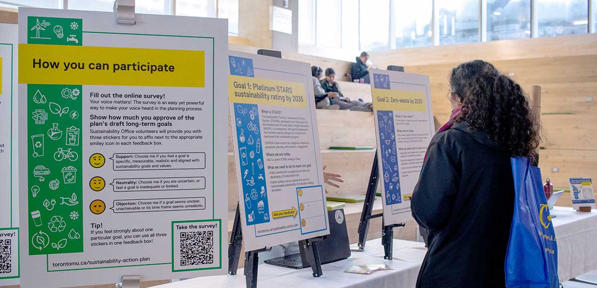 A woman reviews information on a display board at the Outreach Expo.