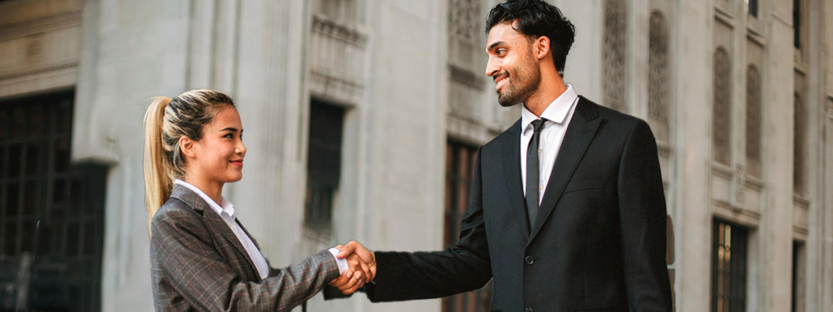 Two business people shaking hands on the street