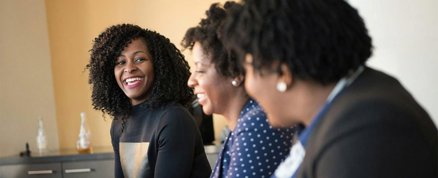 Group of Black students gathered at a table and smiling