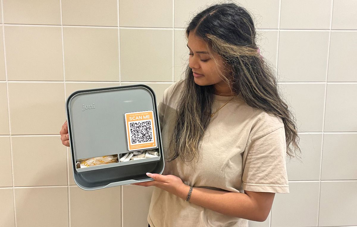 Sinduja Sriskantharajah holding period product dispenser in washroom