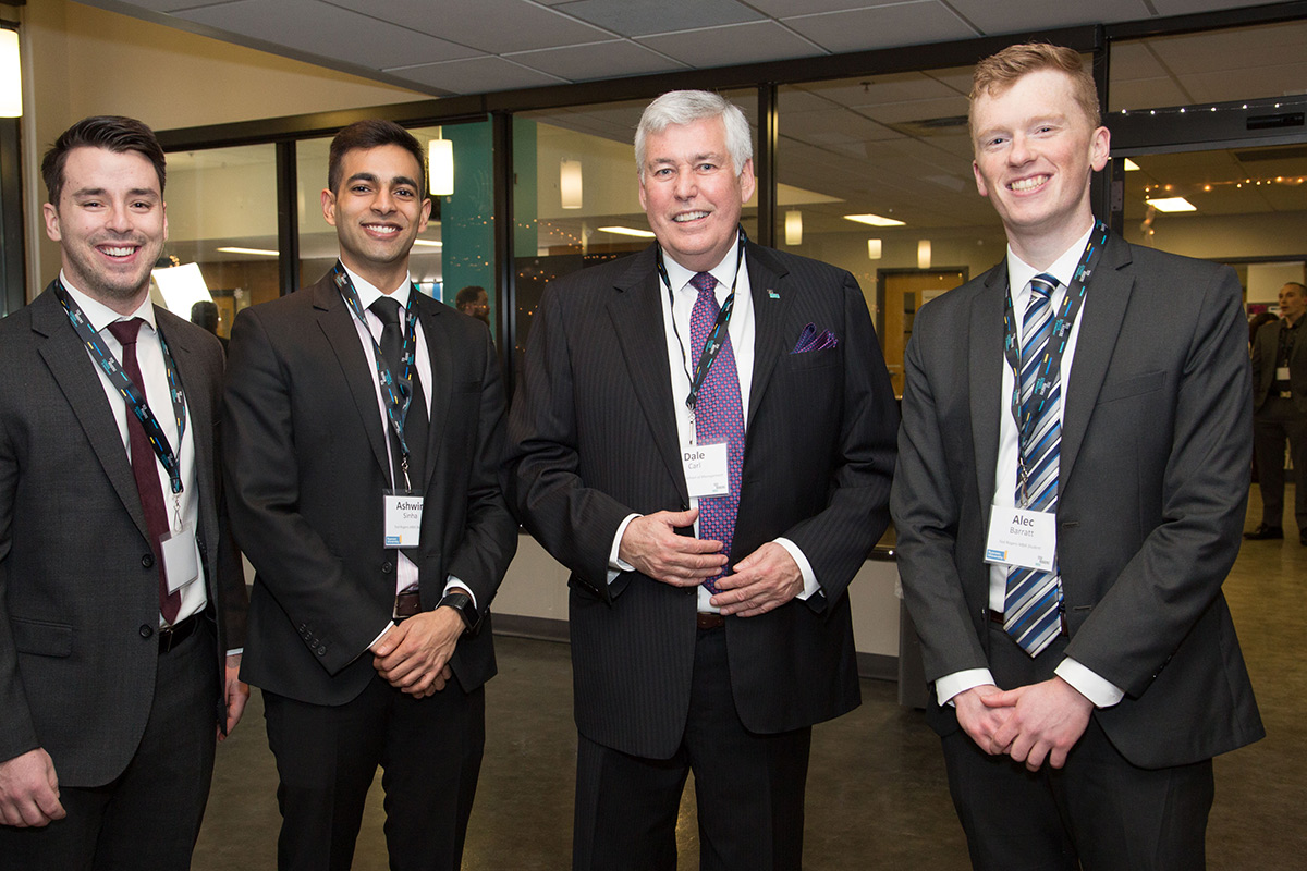 Dale Carl posing for the camera with three students at an event