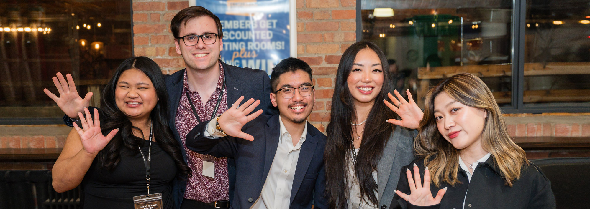 A group of students saying hello with their hands high up