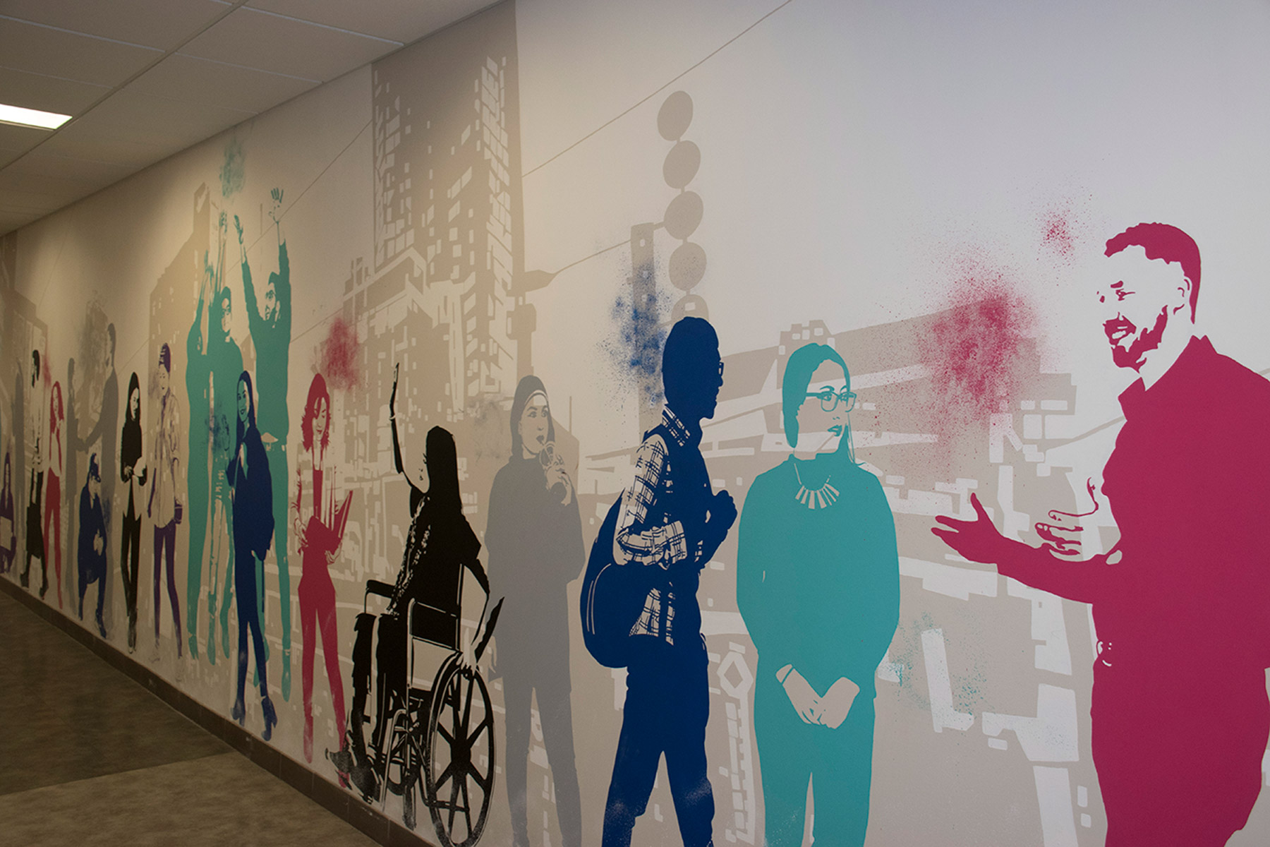 A colourful wall mural of faculty and students