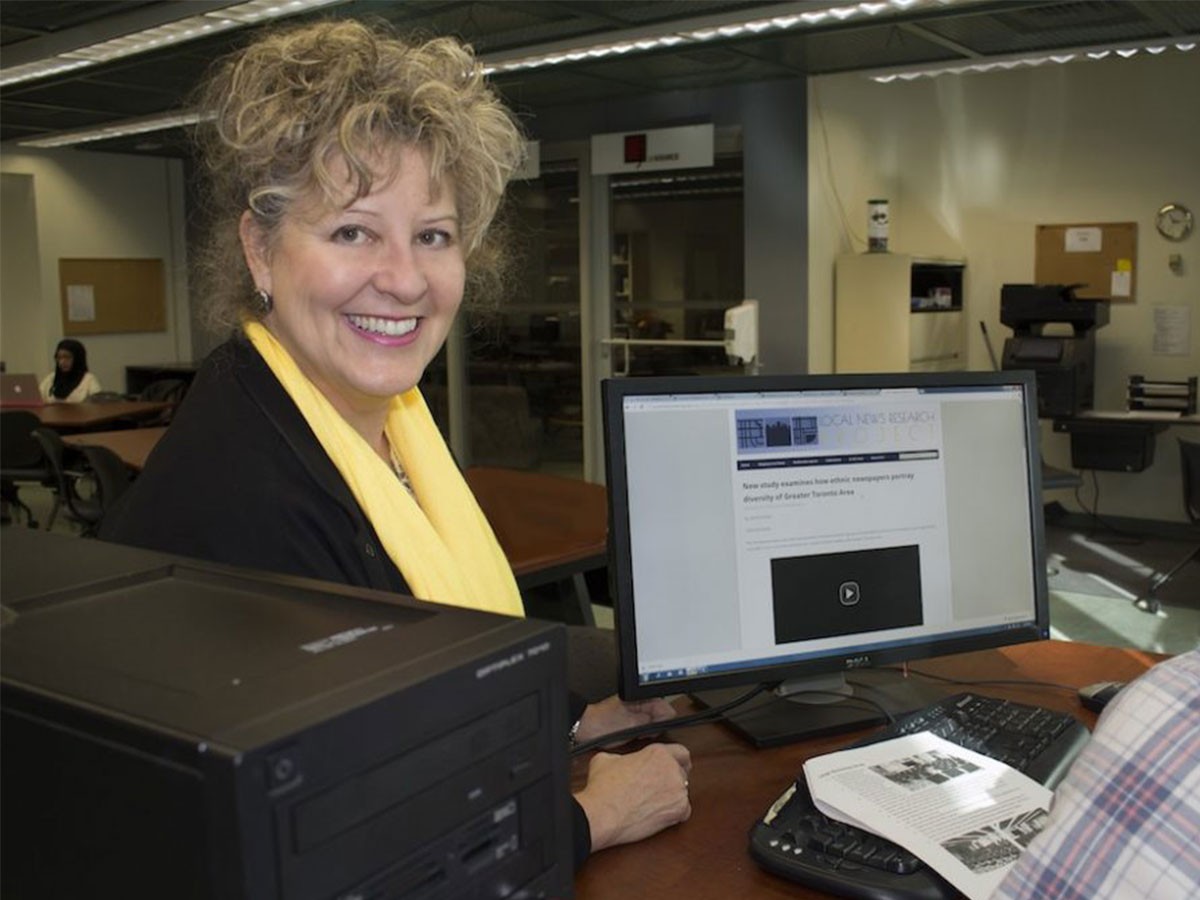  School of Journalism professor April Lindgren in a black shirt and yellow scarf