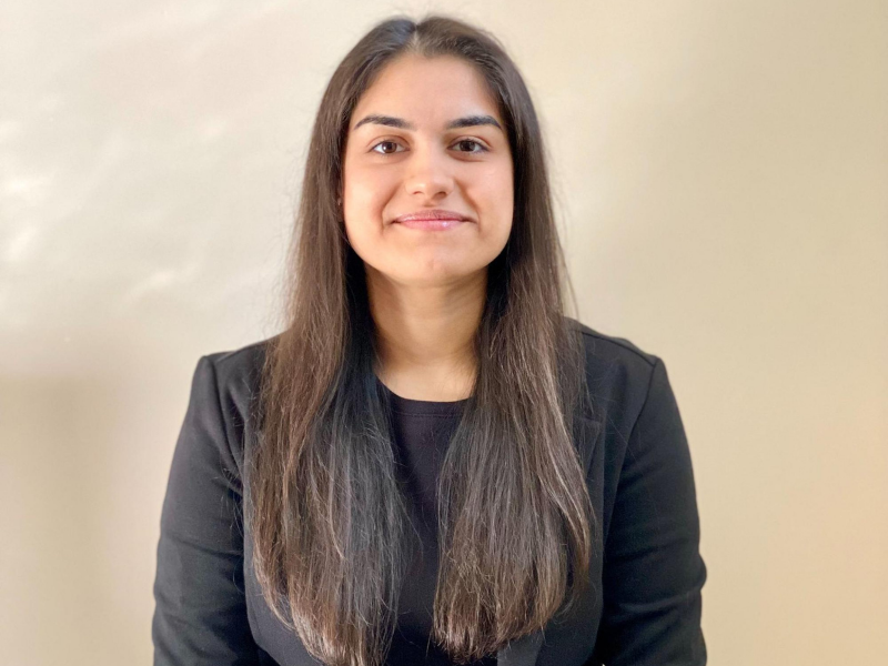 Ryerson student Bhavya Malhotra in black blazer and shirt looks directly at camera 