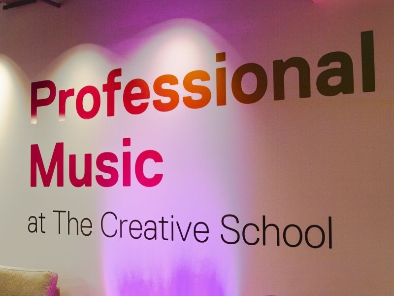 The phrase “Professional Music at The Creative School” painted onto a brightly lit wall.