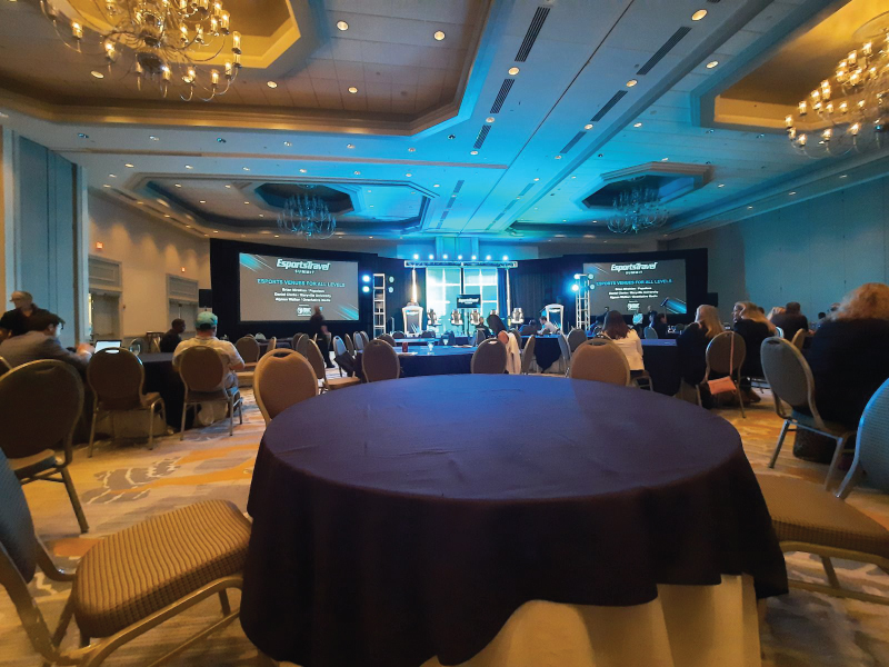 A formal room with circle tables with blue tablecloths