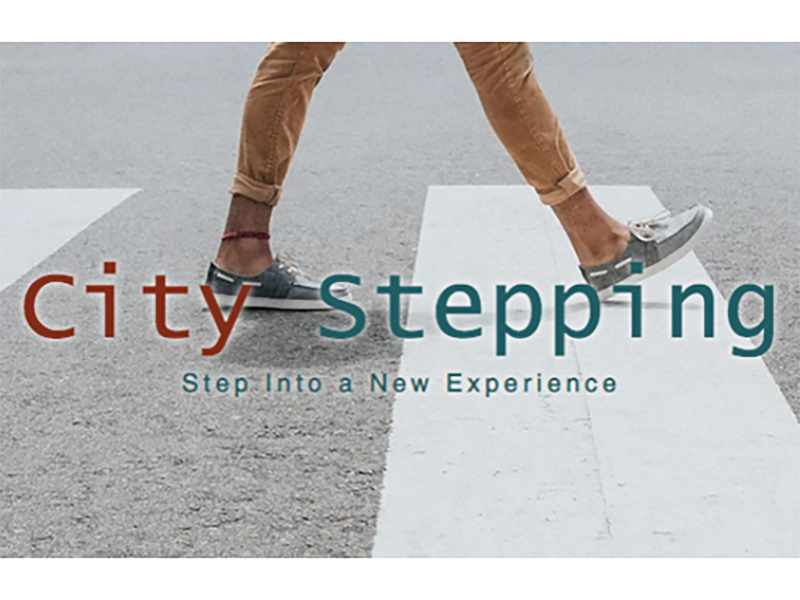 city stepping in red and turquoise blue text with slogan underneath step into a new experience. an individuals are presented as they're walking on a road crossing that is white and grey