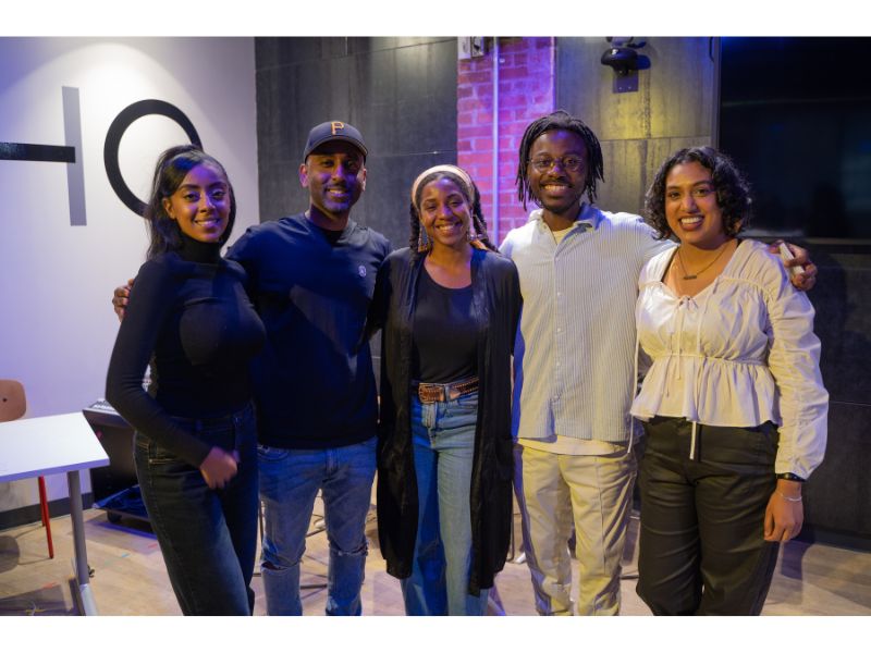 Five people standing together smiling for the camera. 