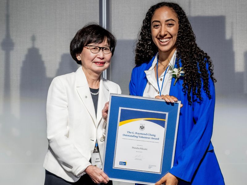 Chancellor Fukakusa hands Diondra Filicetti the G. Raymond Chang Outstanding Volunteer Award.