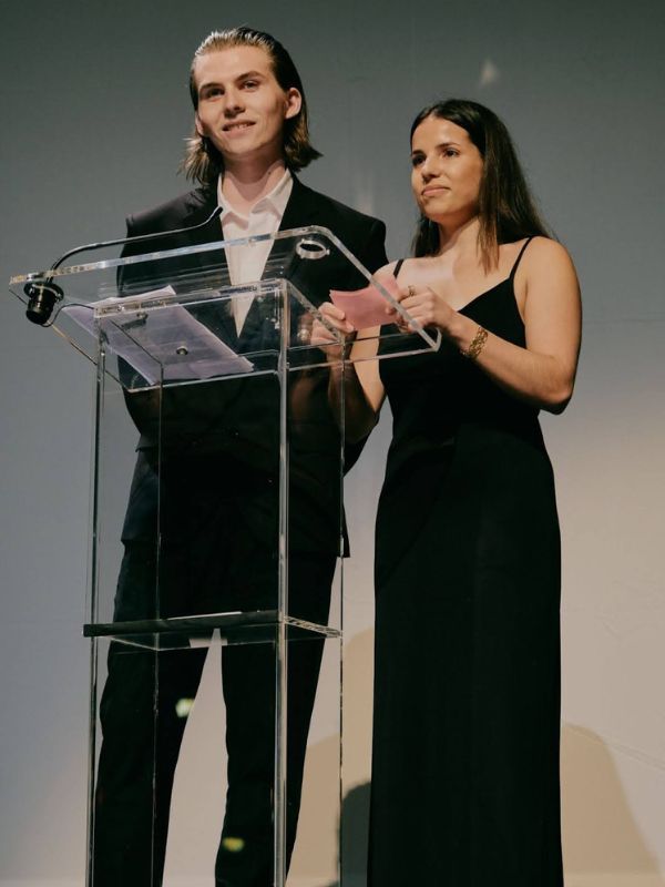 Awards ceremony with two presenters addressing the audience