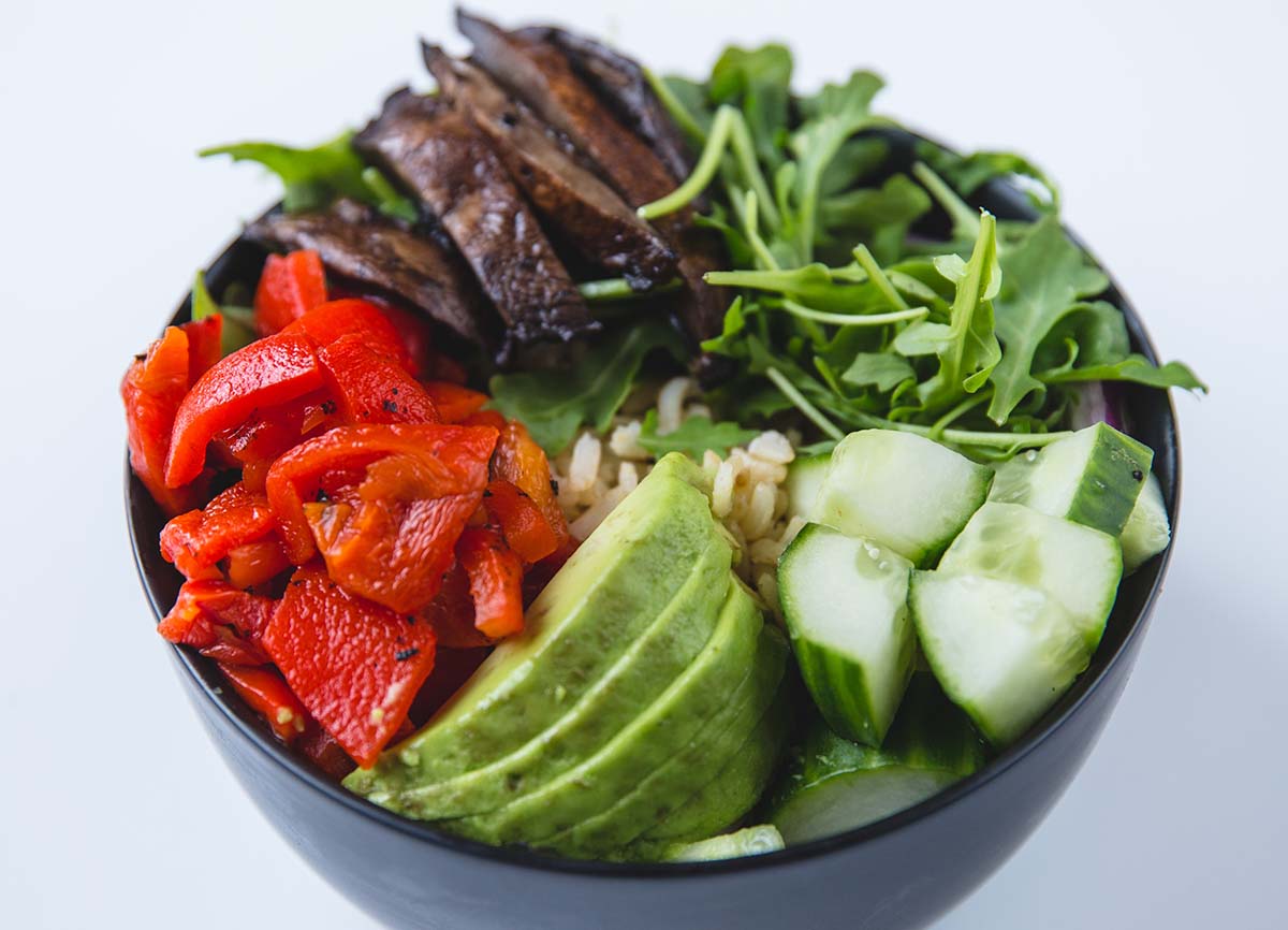 Fresh salad bowl with avocado, cucumbers, mushrooms and peppers