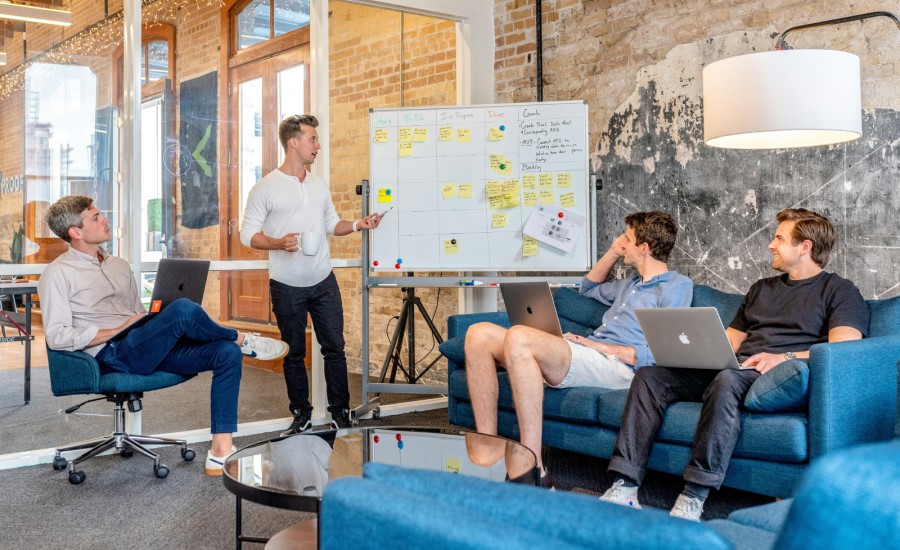 Man presenting to his team sitting with laptops