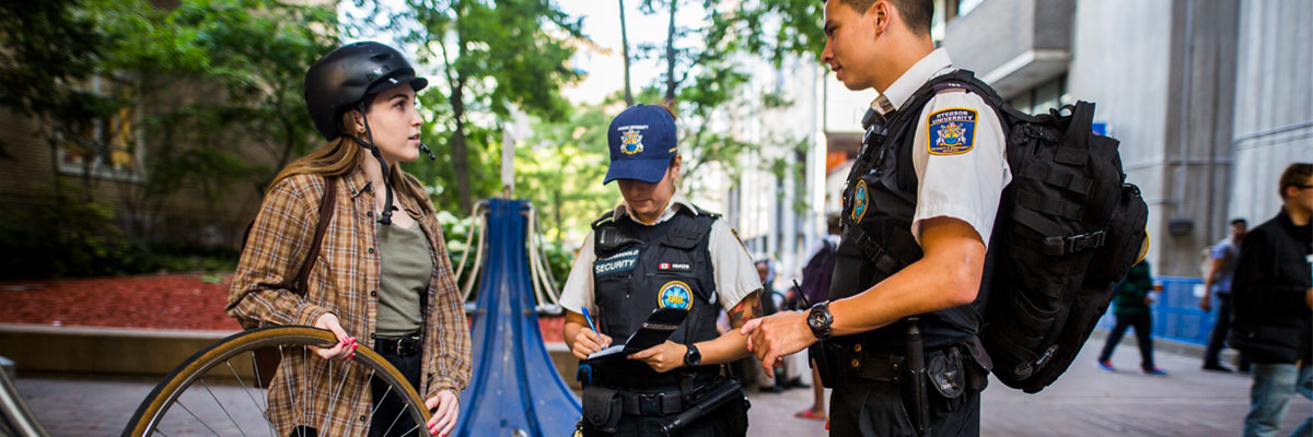 Two members of the security team speaking to a student whose bike was stolen.